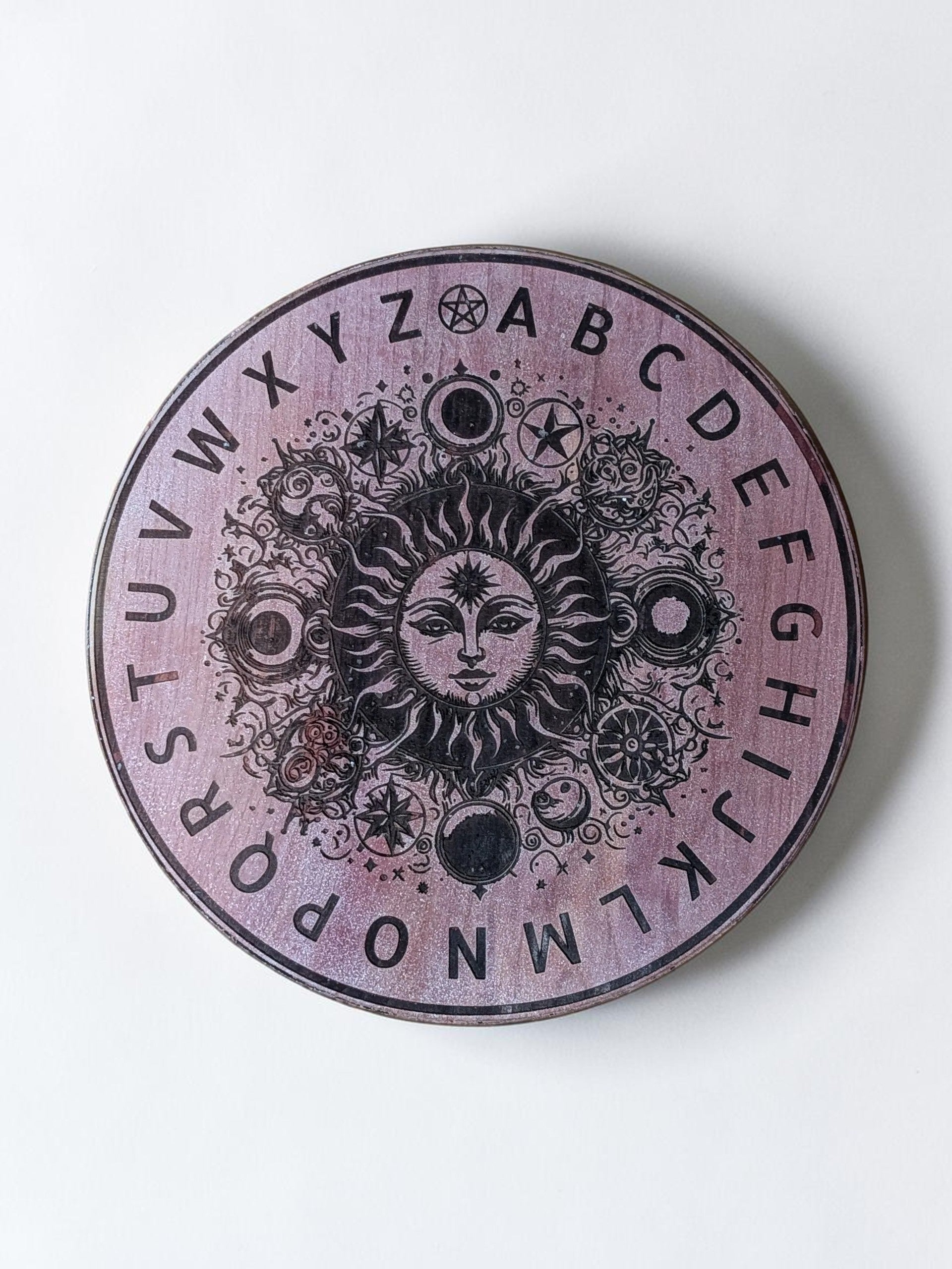 Dogman's Designs wooden pendulum board with sun and celestial design, featuring alphabet letters.
