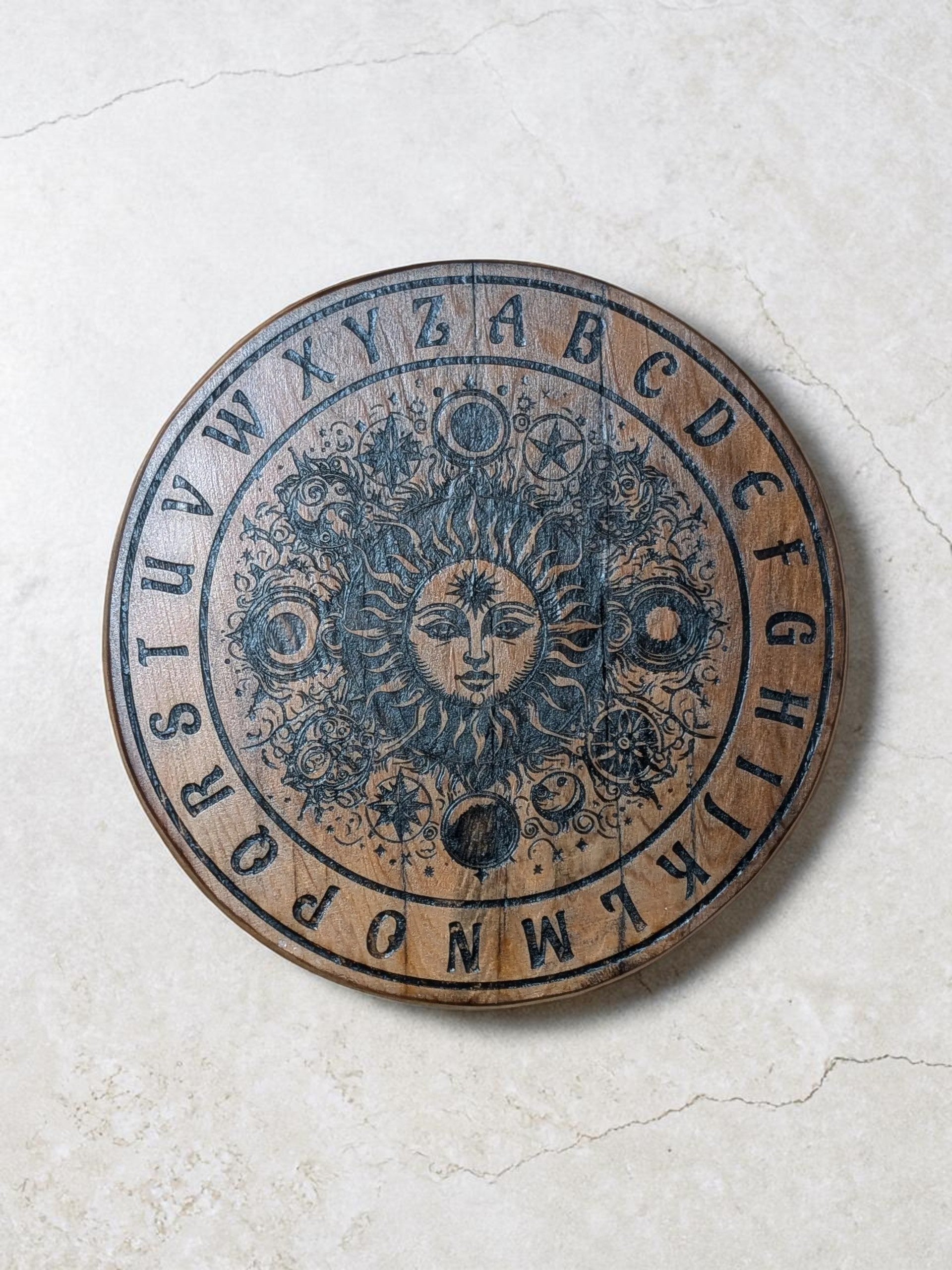 Dogman's Designs wooden pendulum board with sun, moon, stars, and alphabet.